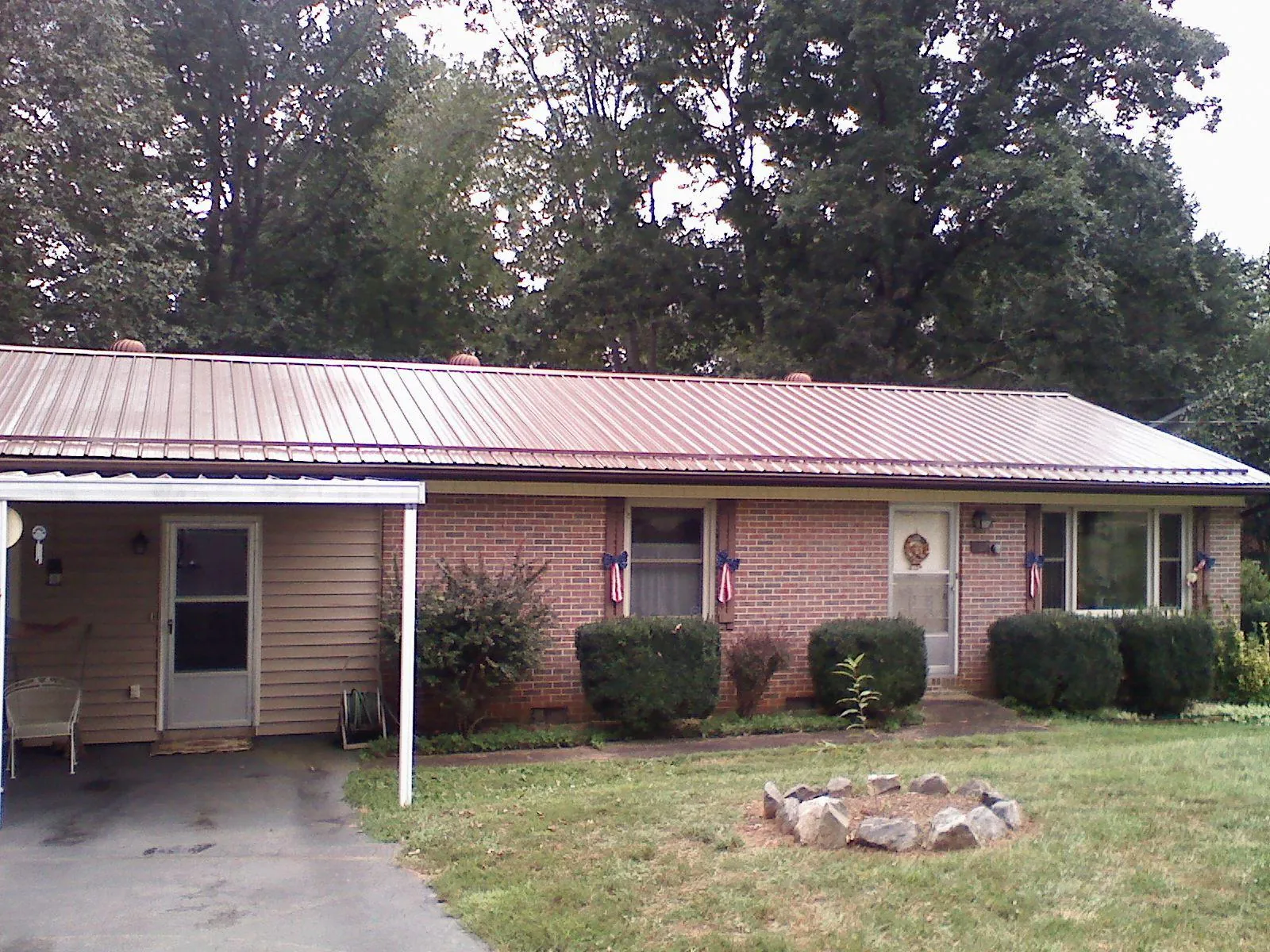 Bronze metal roof and carport on a brick ranch home — Roof Repair work by our crew in Fort Gratiot