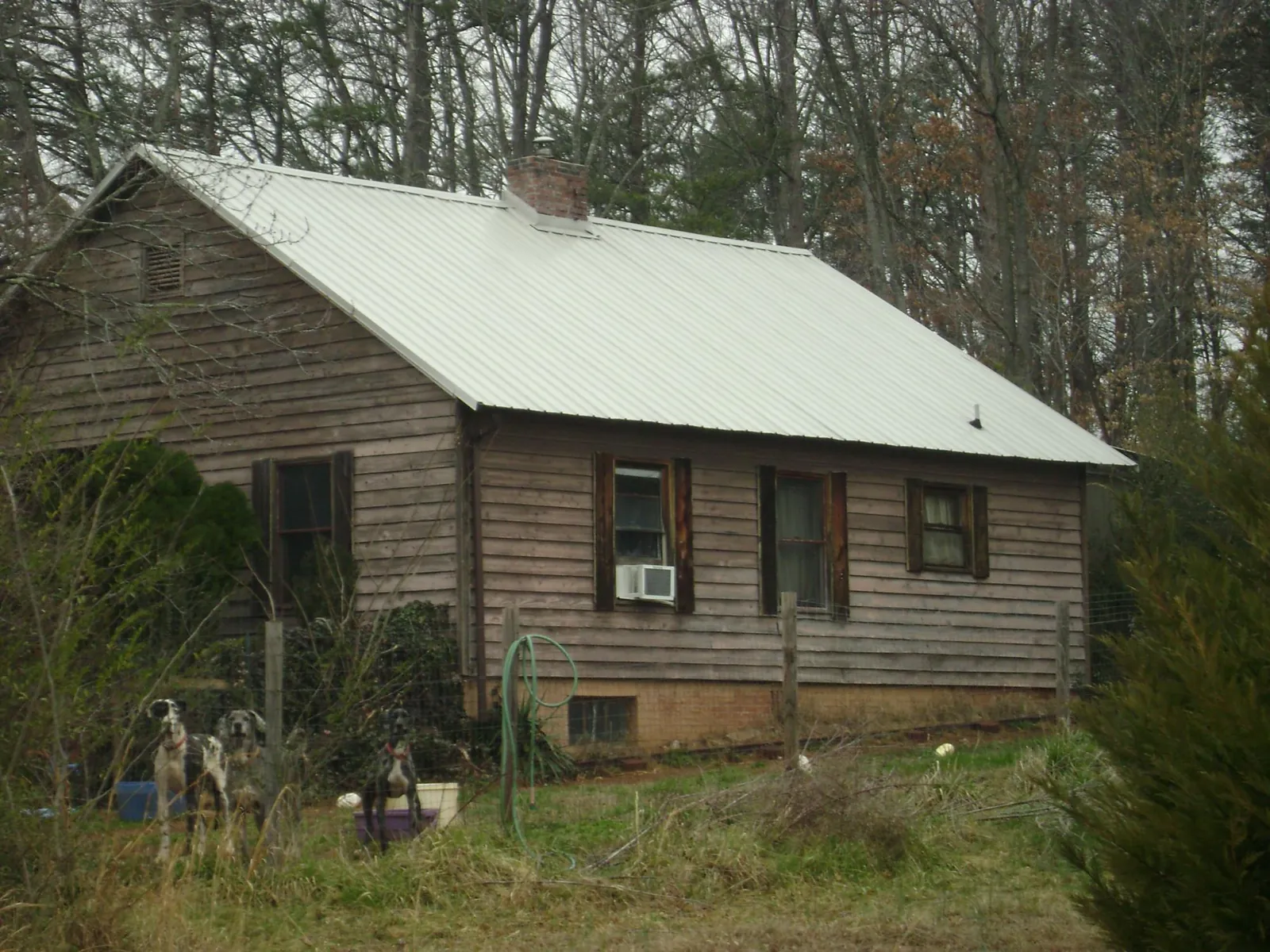 White metal roof on an old wood sided farmhouse, from a Metal Roof Installation job in Fort Gratiot